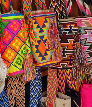 Sacs à dos Wayuu colorés tissés à la main, avec des motifs géométriques et des pompons, suspendus da