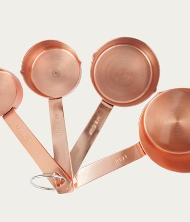 Close-up of copper measuring cups arranged as essential kitchen tools for home cooks