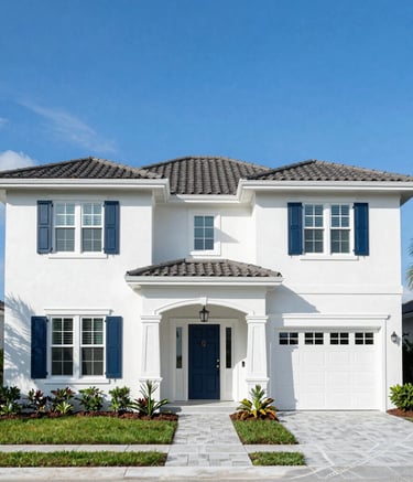 A wide-angle shot of a beautifully finished two-story residential home in Sarasota, Florida. The exterior is painted in a crisp white with dark blue accents on the shutters and door. Professional landscaping, bright blue sky, North American / Florida, US architecture.