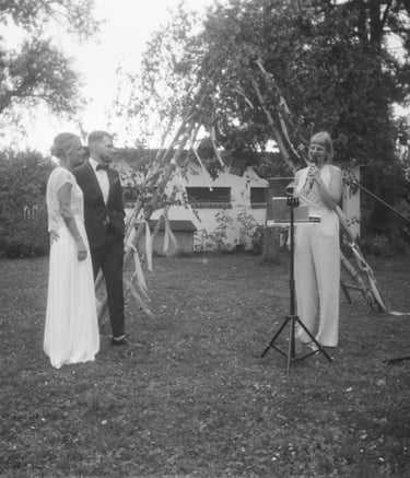 Traurednerin Silke steht bei einer freien Trauung im Freien und spricht vor den Gästen eine persönliche Zeremonierede.