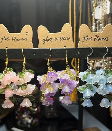 a trio of earrings with clusters of pastel glass flowers on them