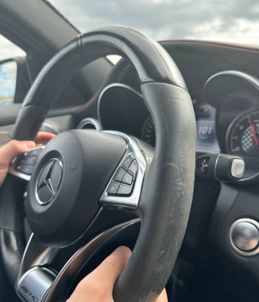 a person holding a steering wheel in a car