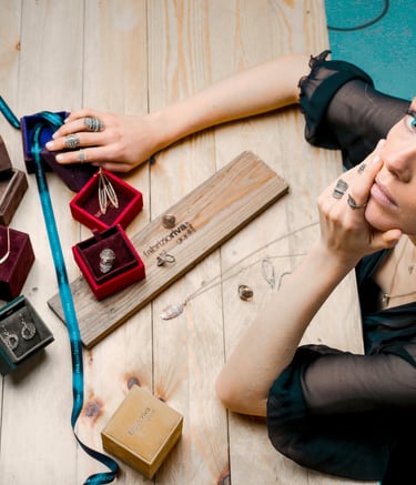 a woman sitting at a table with a ring on her finger
