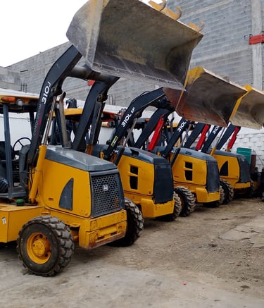 Fila de retroexcavadoras estacionadas en el taller