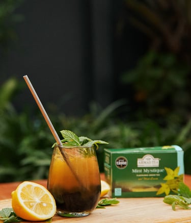a glass of iced tea with a lemonade and mint leaves