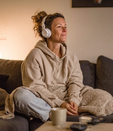 a woman sitting on a couch with headphones on