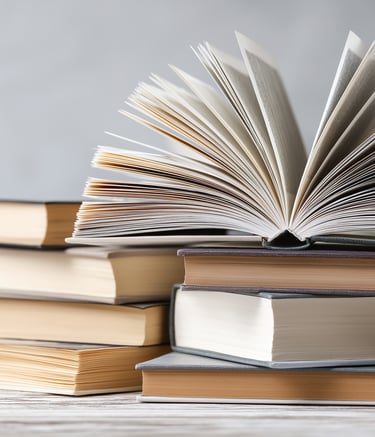 a stack of books with a book open on top of them