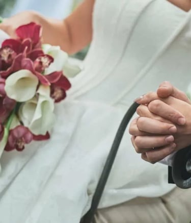 A close-up shot of a bride in a white gown holding a bouquet of burgundy orchids and white calla lilies