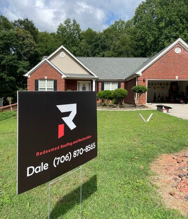 picture of dale sign from redeemed roofing in front of house