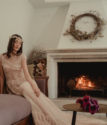 a woman in a long dress sitting on a couch