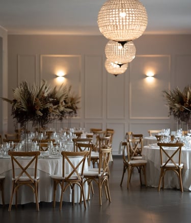 wedding table with white tablecloth and chairs and a chandelier