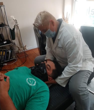 Dr. Lonna Denny performing a traditional neck adjustment to a patient.