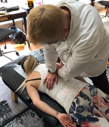 Dr. Lonna Denny performing a traditional spinal adjustment to a patient.
