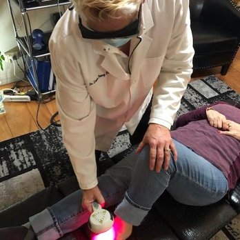 Dr. Lonna Denny performing a cold laser therapy to a patient.