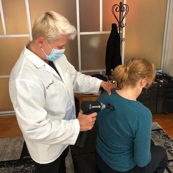 Dr. Lonna Denny utilizing an advanced technology called 'Percussor' to a patient's spine.