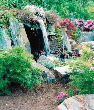 Slate stone grotto with hidden hot tub behind waterfall flowing into natural pool. Carmel Valley, CA