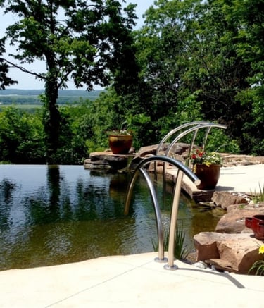 Modern bio pool with infinity edge, minimal plantings & advanced bio bead, UV & ozone filtration.