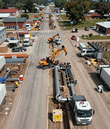 A construction site with multiple concrete formwork structures in place. Metal braces and supports are prominently visible, ensuring the stability of the forms. Concrete foundations and vertical columns are being prepared, with a mix of exposed rebar and newly laid concrete. The overall environment appears organized and active, reflecting ongoing building activities.