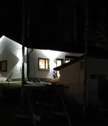 uusi talo jossa valot valaisevat taloa komeasti.