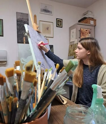 a woman is painting a picture on a easel