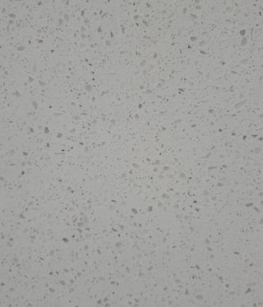 Close-up of light gray quartz slab with speckled texture