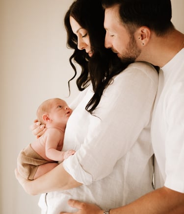 couple holding newborn baby where baby bump was, in studio Adelaide Hills 