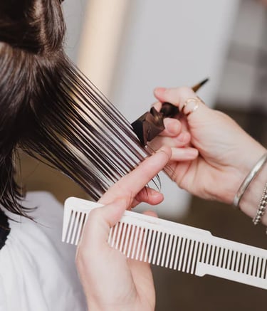 a woman is getting her hair cut by a hairdressucker