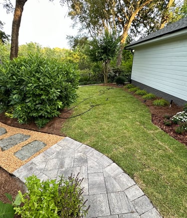 a walkway with a stone path leading to a bench
