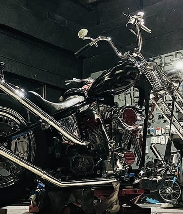 custom motorcycle parked on a lift inside of Schmidt Motos