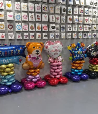Colorful birthday party balloon display with Happy Birthday letters, a giant number 6, and a cupcake balloon.