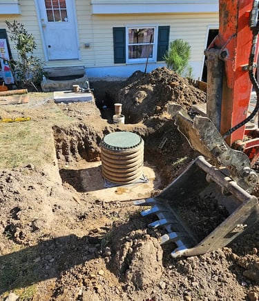 stormwater device in dirt next to excavating machine