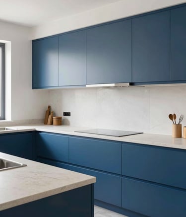 Photography of a modern kitchen renovation project in a Southern European / Spanish home. The scene shows a clean, bright space with steel blue cabinets and off-white stone countertops. The style is contemporary and professional, showcasing the quality of work.