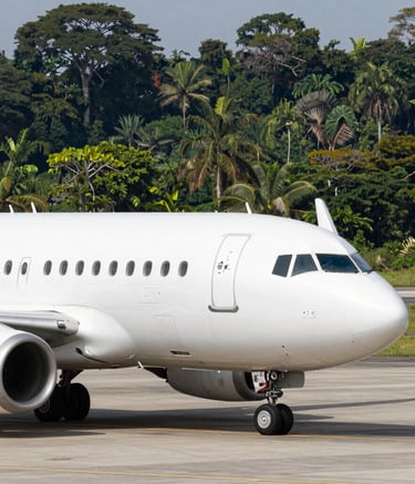 Close up of an airplane on a modern tarmac with a background of a dense tropical rainforest, emphasizing clean aviation and nature harmony, bright daylight, no people, professional photography, Latin American / Spanish-speaking context.