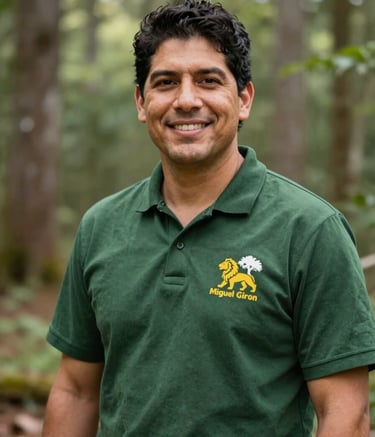 A premium portrait of Miguel Giron, a Latino immigrant arborist with a friendly yet professional expression. He is standing outdoors with a backdrop of beautiful South Carolina woodland. He wears professional arborist gear with a visible lion and tree emblem logo. The style is trustworthy and approachable, using a palette of deep greens (#1A2C21, #2F5C3E) and natural light.