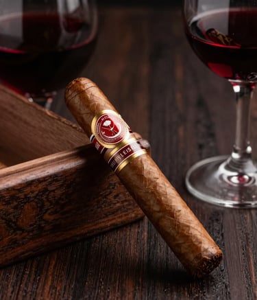 High-end product photography of a premium hand-rolled cigar resting on a dark mahogany surface next to a glass of deep red wine, Brazilian luxury setting, soft directional lighting, colors of dark brown and burgundy red.