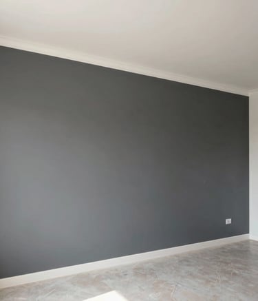 A wide-angle professional photograph of a freshly painted interior space in Ankara, showcasing a feature wall with a sophisticated charcoal grey texture next to a clean white-ish ceiling. The room is filled with soft natural light, highlighting the smooth, high-end finish and minimalist furniture in a Middle Eastern setting.
