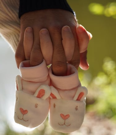 a person holding a pair of baby shoes