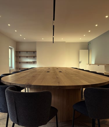a large wooden table with chairs and chairs in a large office space