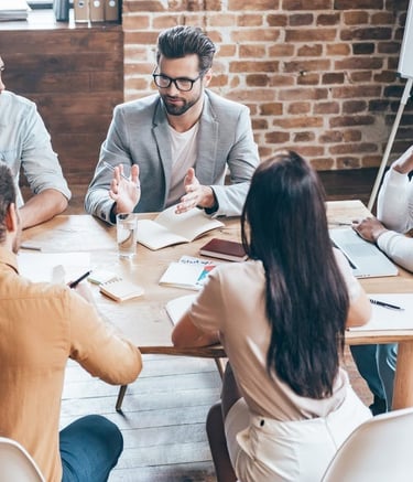a group of people sitting around a table with papers and papers
