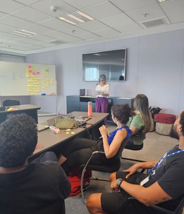 Gabriela Bechara Zillig conduz dinâmica de Design Sprint em uma sala de reunião para colegas
