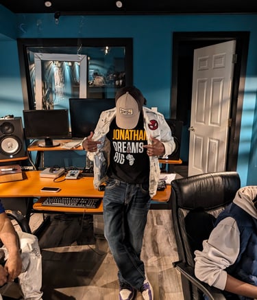 hazema in a baseball cap by a audio recording studio desk