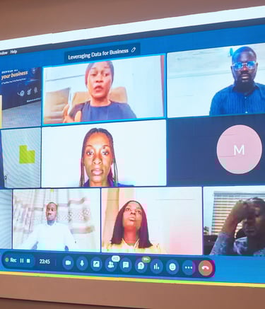 A virtual business meeting on a monitor featuring a video conference with multiple participants.