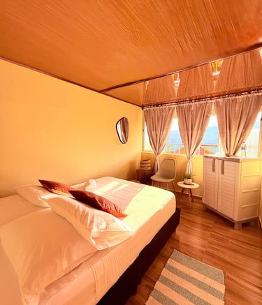 Habitación sencilla con cama doble, ventana con vista a la montaña