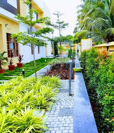 Seamless indoor-outdoor landscape transition with potted greenery and pathway by Garden Designers