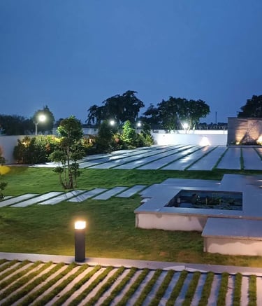Garden lighting illuminating plants and walkways at dusk by Garden Designers