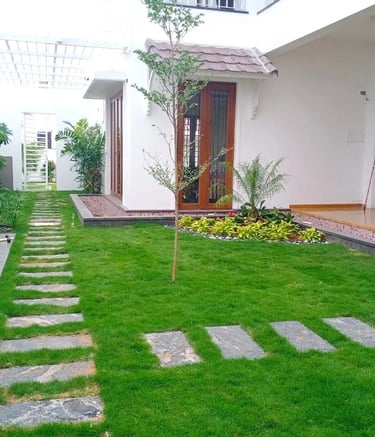 Residential landscape with lush green lawns and flowering borders designed by Garden Designers