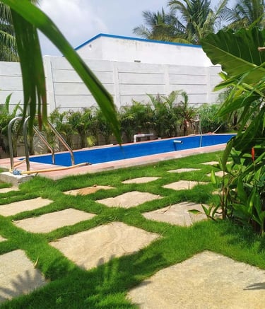 Tropical resort garden with poolside greenery and palm trees by Garden Designers