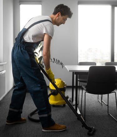 a man in overalls and overalls cleaning a room