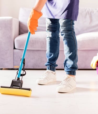 a person cleaning a living room with a broom and a broom