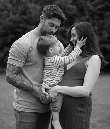 Black and white photo of a family pregnant mother holding her son 